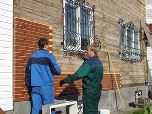Процесс облицовки фасадной стены кирпичом